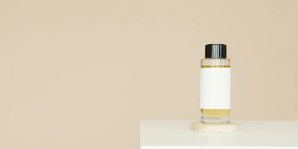 A sleek cosmetic bottle with blank label on a clean white platform against a neutral background