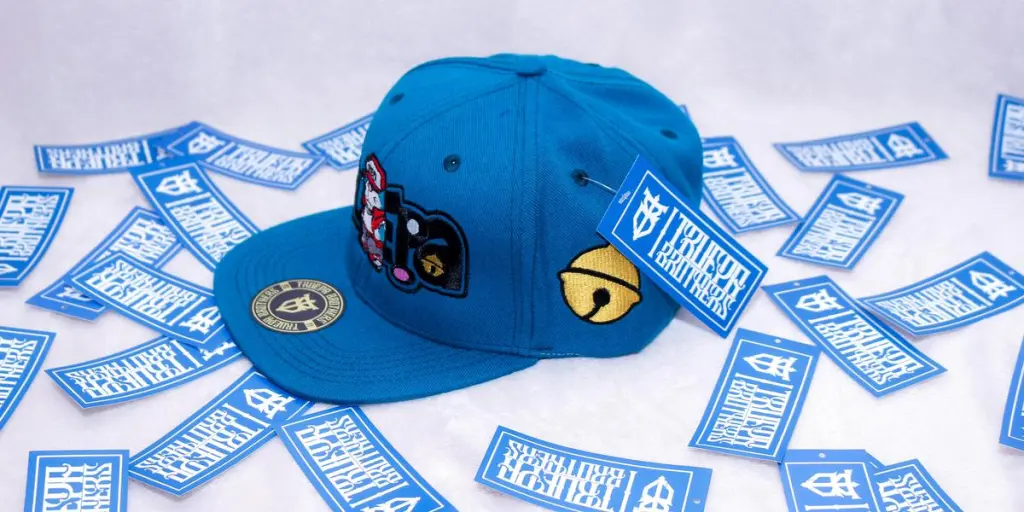 A vibrant blue baseball cap surrounded by branded stickers in a studio setup