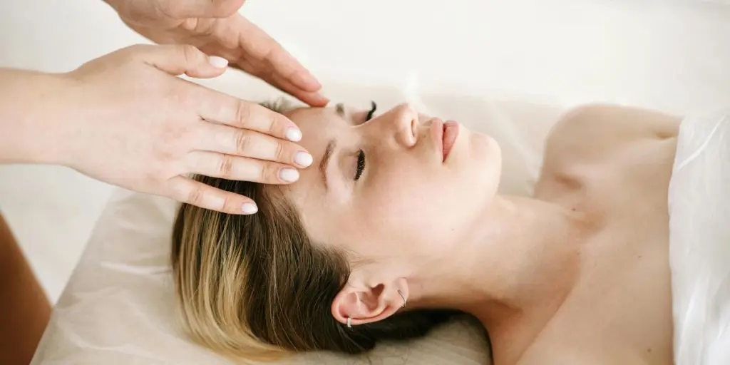 Een vrouw geniet van een ontspannende gezichtsmassage in een spa voor therapeutische voordelen