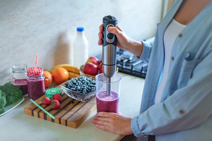 A woman using a cordless immersion blender