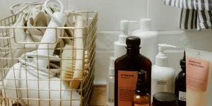 Aesthetic arrangement of bathroom products and accessories in a wire basket on a wooden shelf