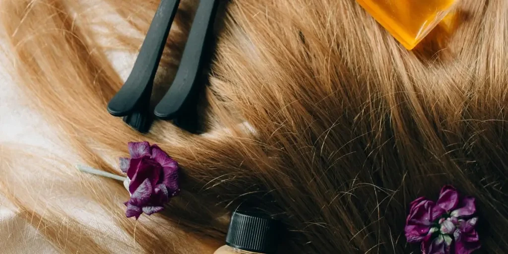 Aesthetic flatlay of hair care items and flowers against a soft background