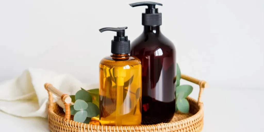 Amber glass pump bottles of shampoo and liquid soap in rattan tray