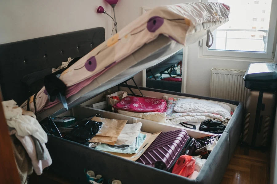 Tempat tidur ottoman yang penuh dengan barang-barang