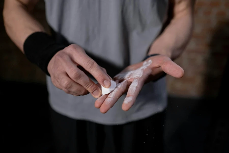 Athletes hands applying gym chalk before exercise for improved grip
