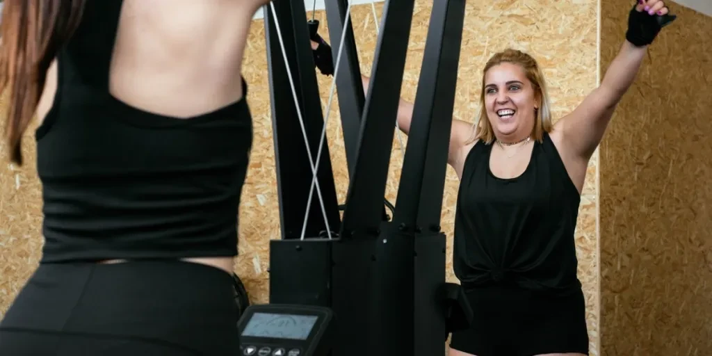 Chica atlética usando una máquina de esquí durante el gimnasio