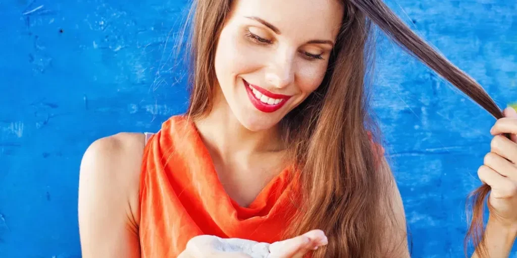 Beautiful caucasian woman in red t-shirt with white powder in her palm