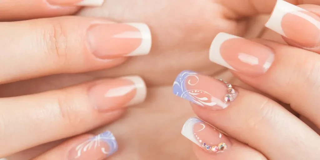 Hermosas manos femeninas con manicura francesa en primer plano