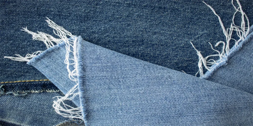 Texture di jeans blu o sfondo denim con cucitura e filo