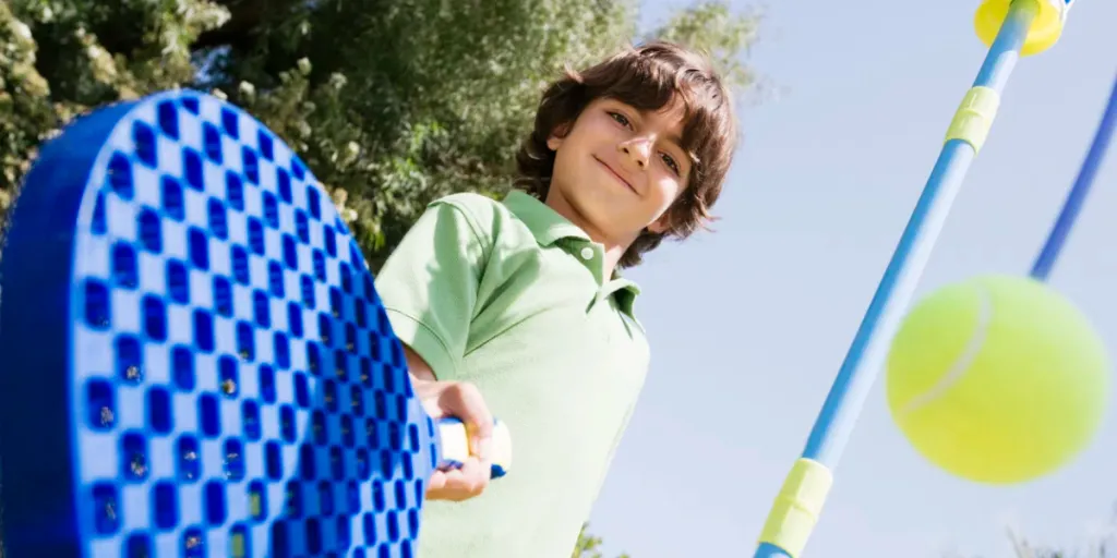 Menino brincando com remo e bola amarrada