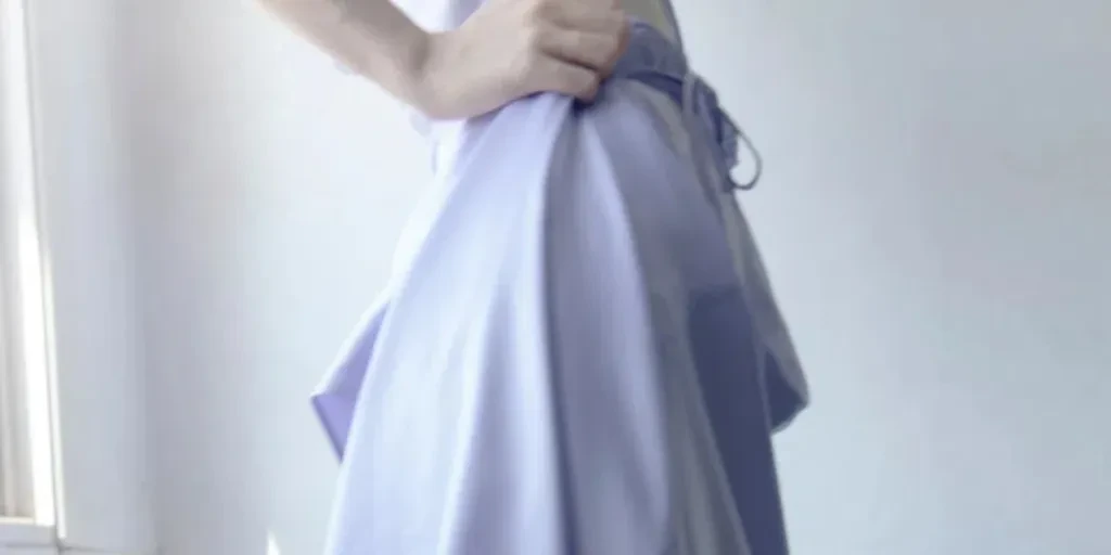 Detail close-up gaun ungu muda yang dikenakan oleh model fesyen muda