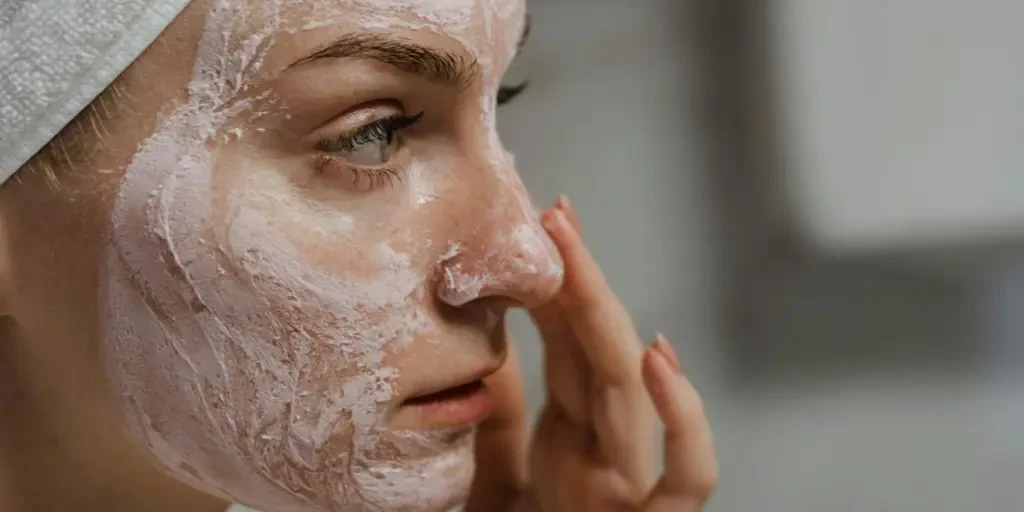 Close-up of a woman applying facial cream as part of her skincare routine, enhancing skin health