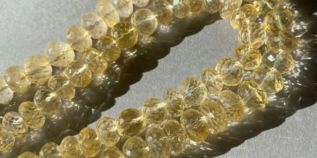 Close-up of citrine quartz beads casting shadows in bright sunlight