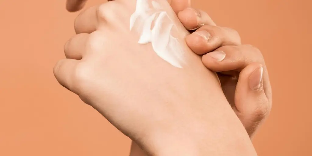 Close-up of hands applying moisturizer, promoting skincare and softness