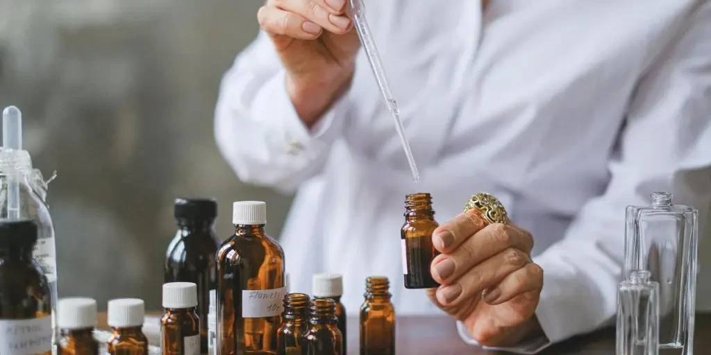 Close-up of hands handling amber glass bottles during an aromatherapy session