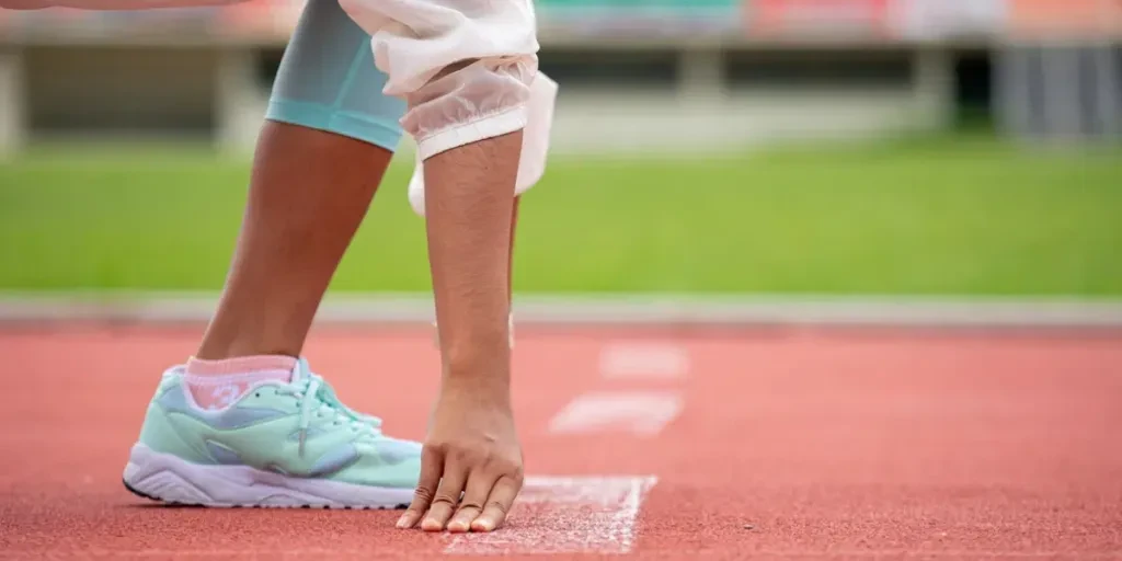 Close-up of runner in starting position on running track