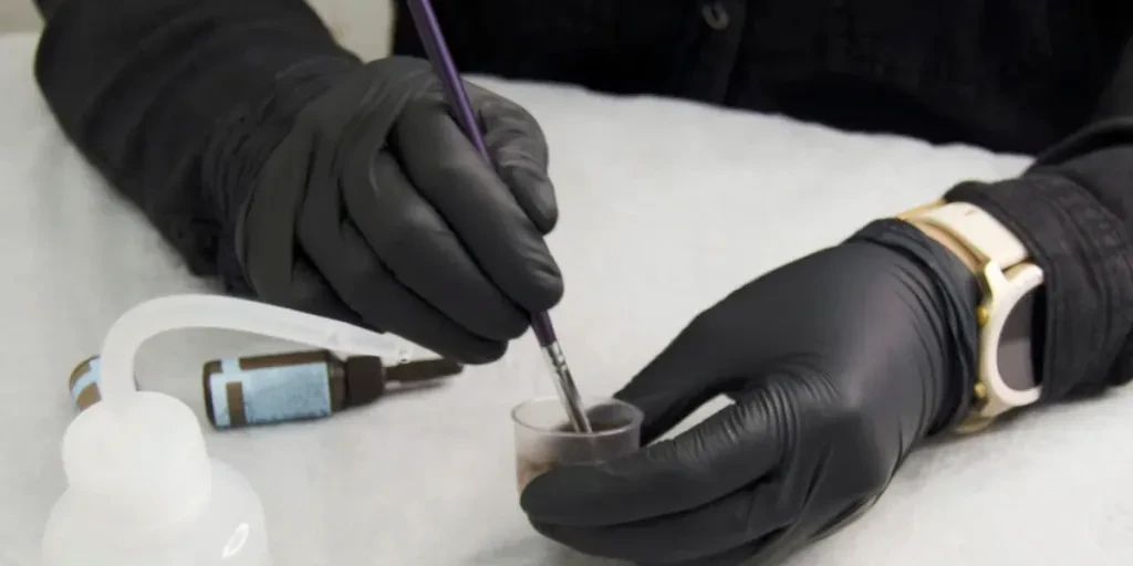 Close-up of the eyebrow master's hands stirring the eyebrow dye