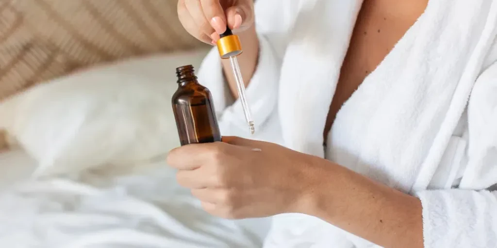 Close-up of woman applying cosmetics oil in morning