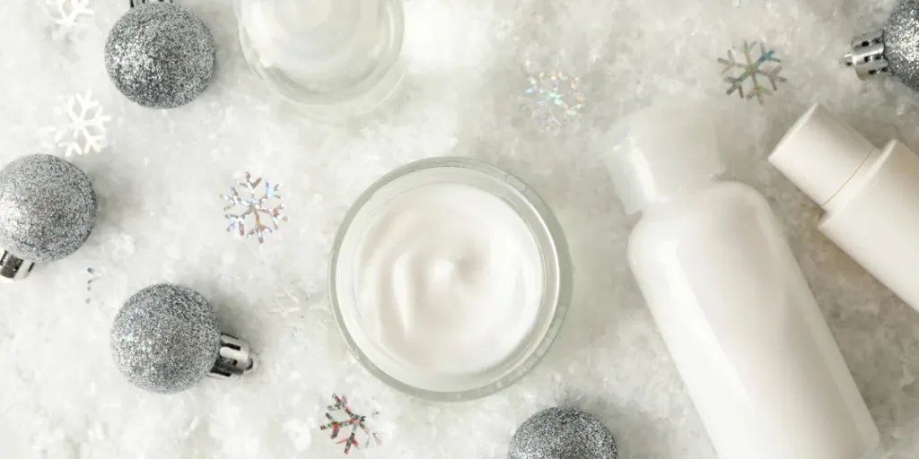 Concepto de cuidado facial con cosméticos sobre fondo de nieve decorativa