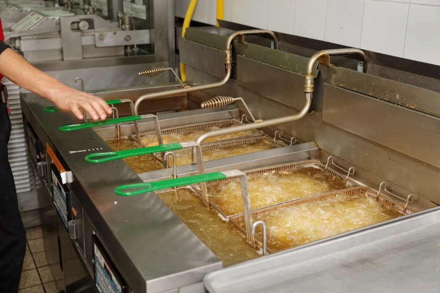 Deep fryers with boiling oil on fast food kitchen