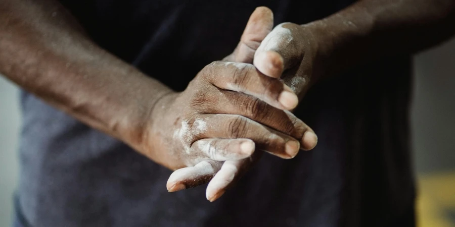 Primo piano dettagliato di mani spolverate di cipria, evidenziando la consistenza e il colore