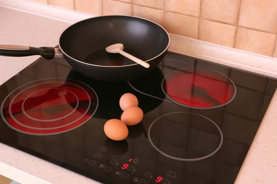 Des œufs et une poêle sur une cuisinière électrique