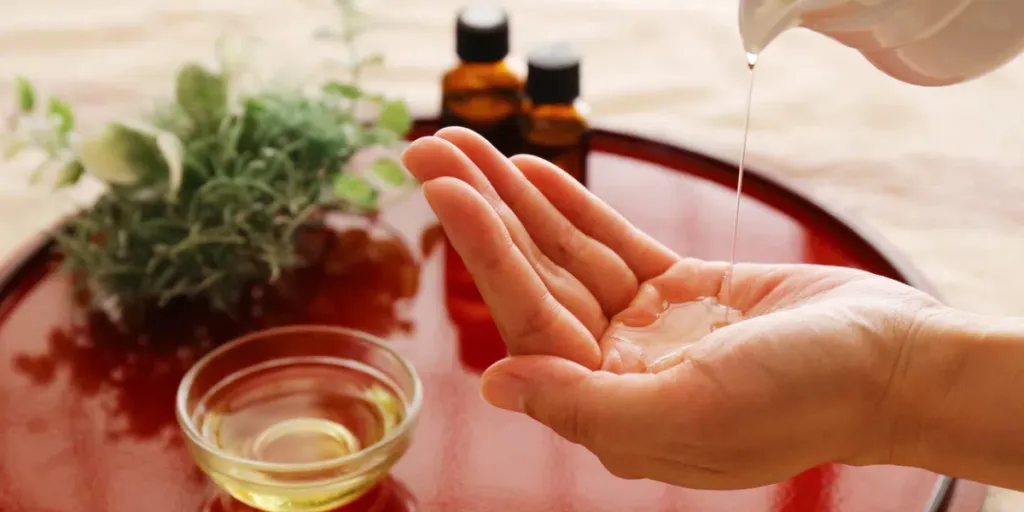 Essential oil bottle and beeswax on a red tray