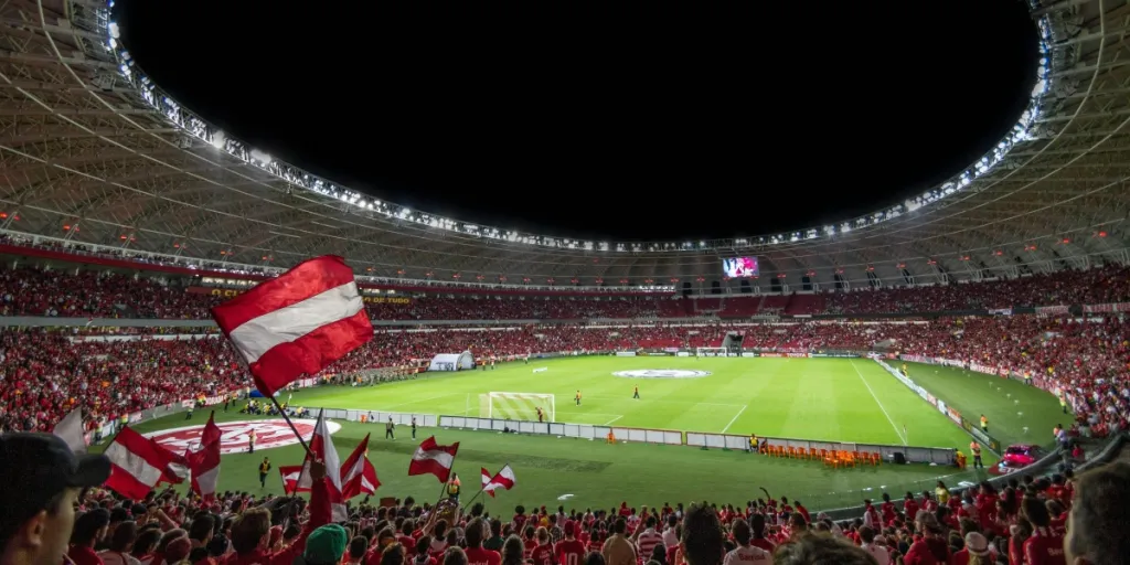 Emocionante partido de fútbol con aficionados entusiastas en un estadio repleto bajo luces brillantes