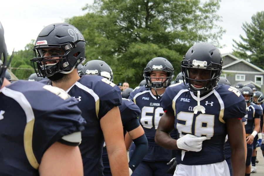 I giocatori di football in divisa blu navy si preparano per una partita all'aperto con determinazione e spirito di squadra