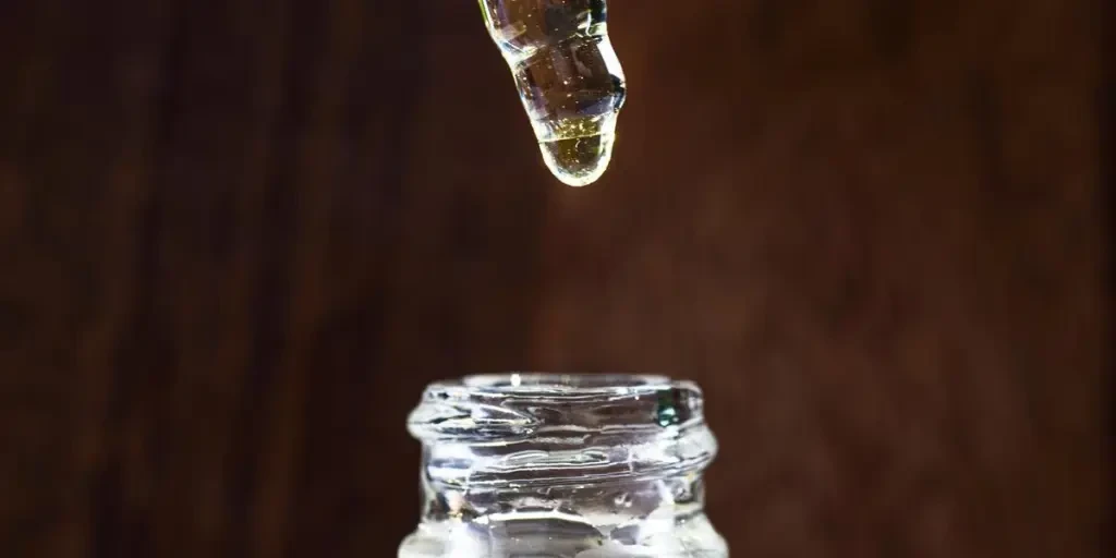 Glass Jar Of Face Oil And A Dropper Above It