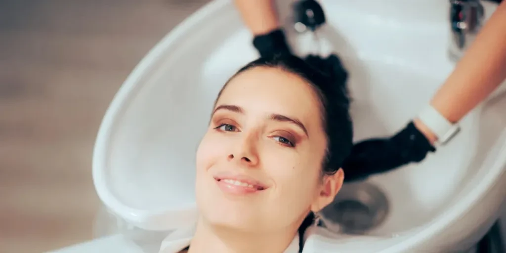 Hairdresser washing hair while doing a scalp massage