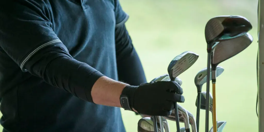 Hand of senior man practicing on golf course