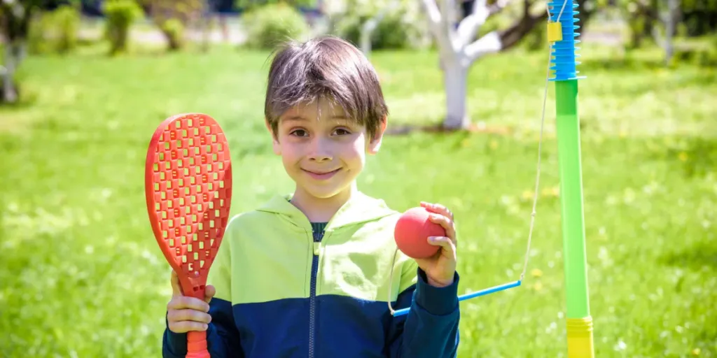 Menino feliz está jogando tetherball swing ball no acampamento de verão3