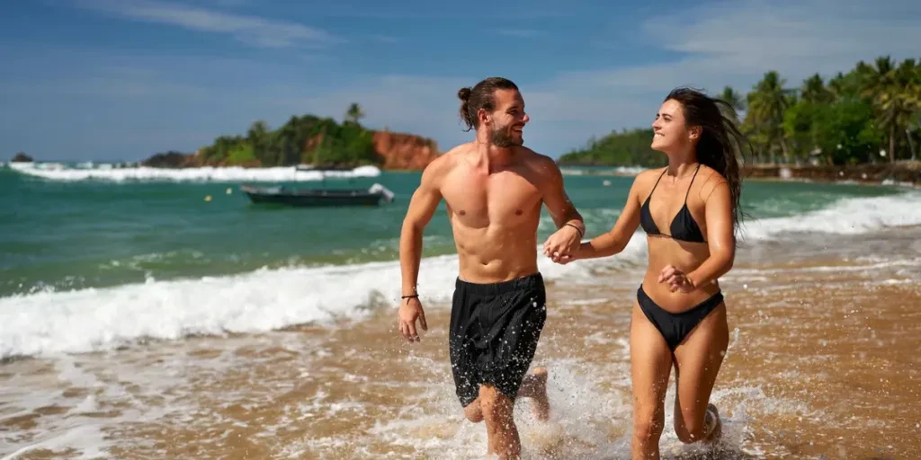 Un couple joyeux court sur une plage tropicale