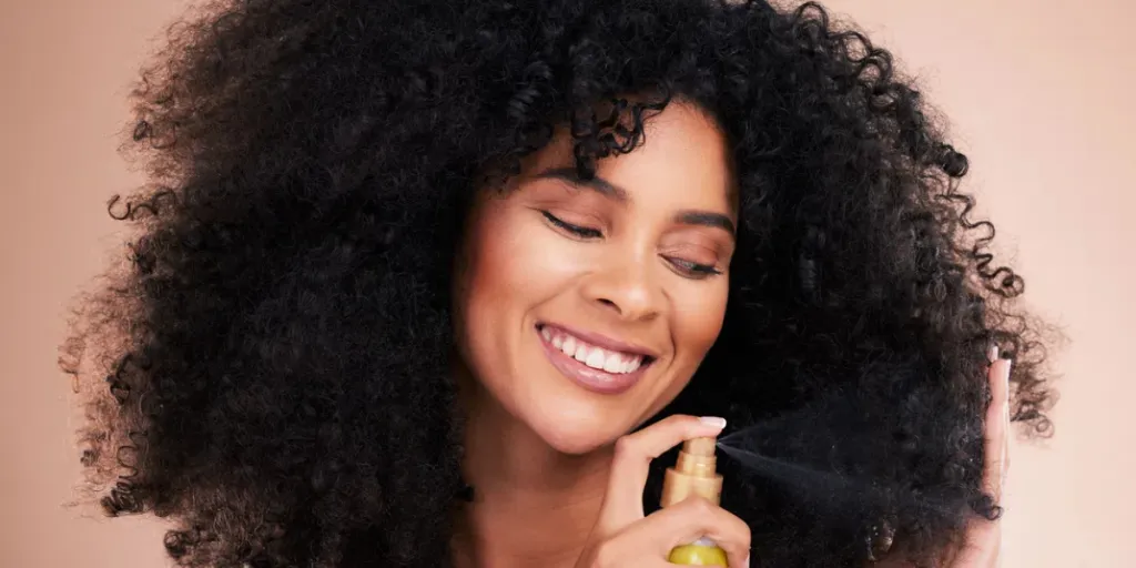 Model, happy or afro hair spray on isolated studio background in frizz control