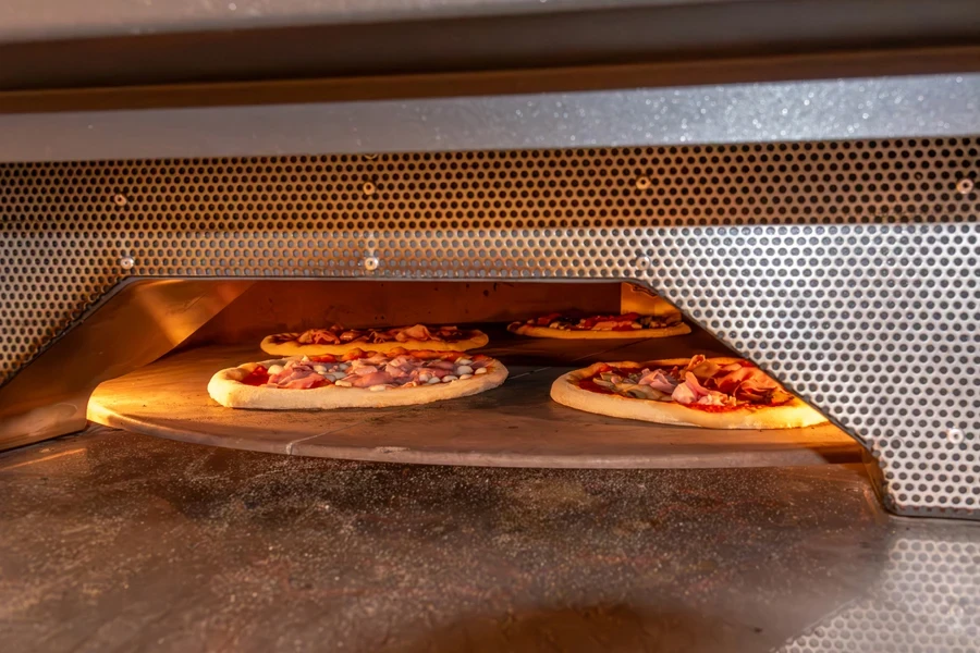 Plusieurs pizzas cuisent dans un four électrique