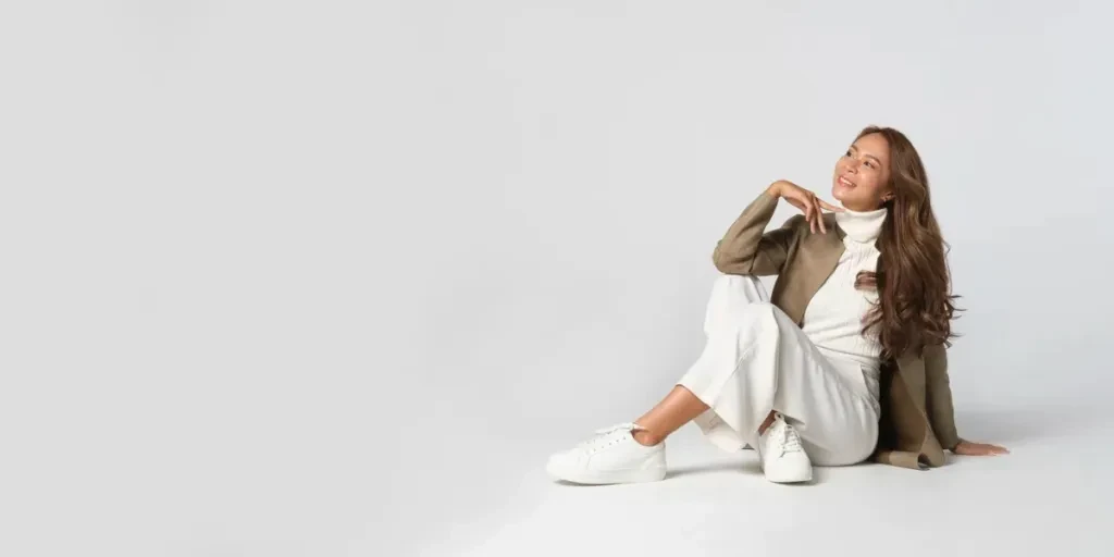 Panoramic photo of beautiful elegant young woman in brown jacket posing on white background