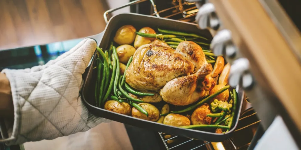 Orang mengeluarkan makanan dari oven konvensional