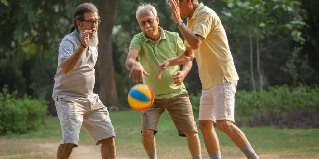 Amigos varones mayores y juguetones driblando la pelota de baloncesto en el césped