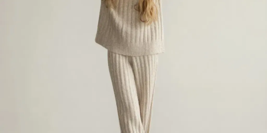 Portrait d'une belle jeune femme portant un pull et un pantalon en tricot beige