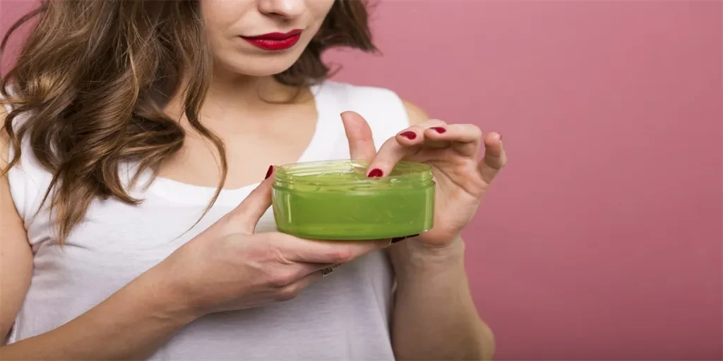 Mujer bonita sosteniendo una botella con crema facial