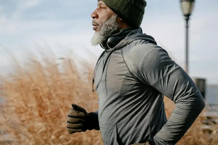 Senior African American man enjoying a run outdoors in warm autumn clothing