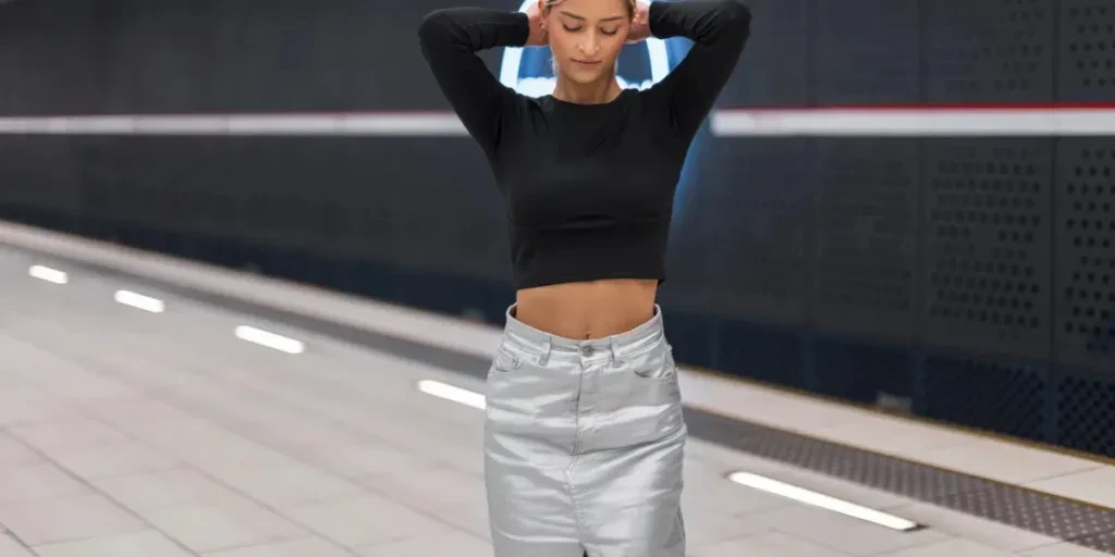 Stylish beautiful young woman model in fashion clothes with a black top and silver skirt