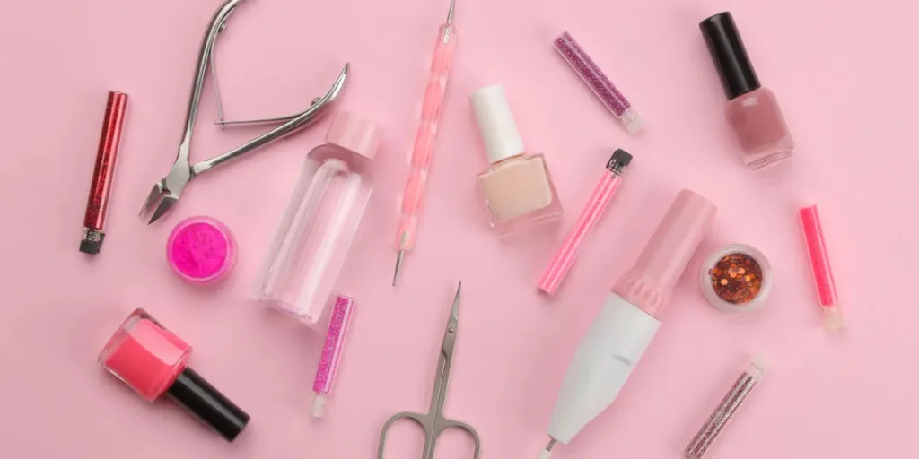 Various tools and things for manicure and pedicure on a pink background