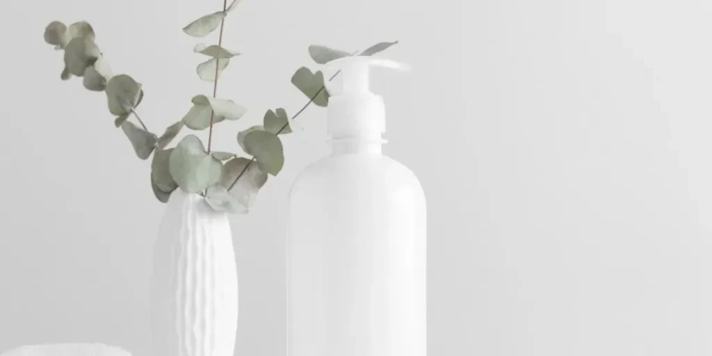 White cosmetic liquid soap dispenser bottle mockup with a towel