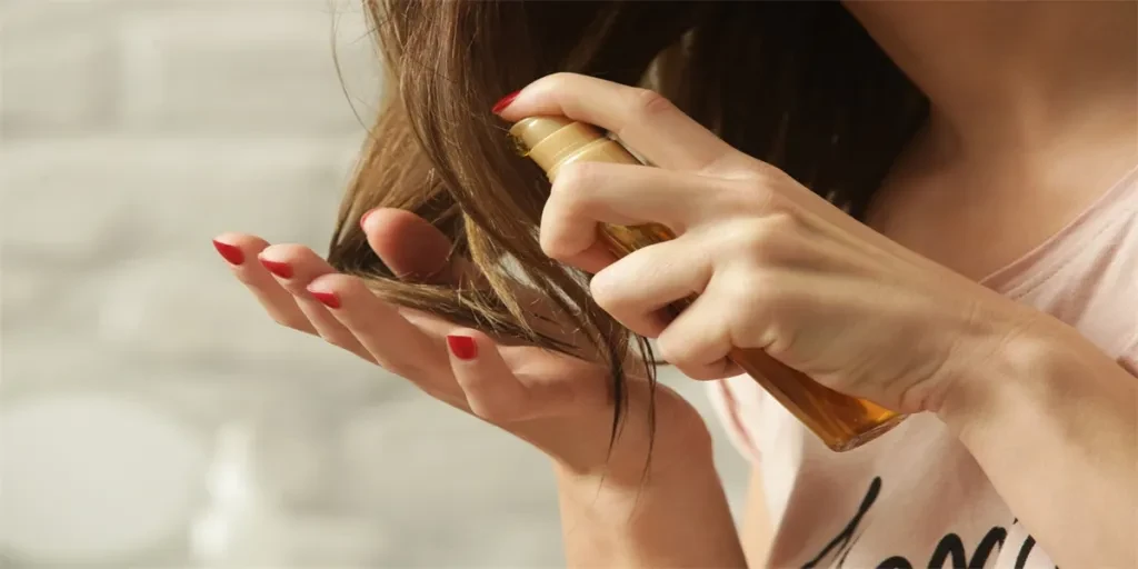 Mujer aplicando aceite en las puntas del cabello