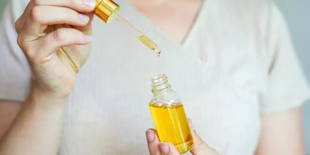 Woman holding glass bottle with spa cosmetic oil