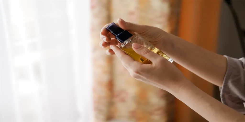 Femme tenant une bouteille de pompe cosmétique en verre