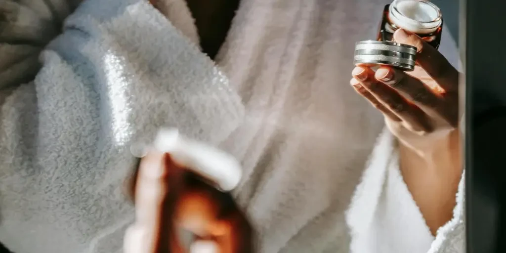 Woman in bathrobe applying skincare cream for a calm morning routine