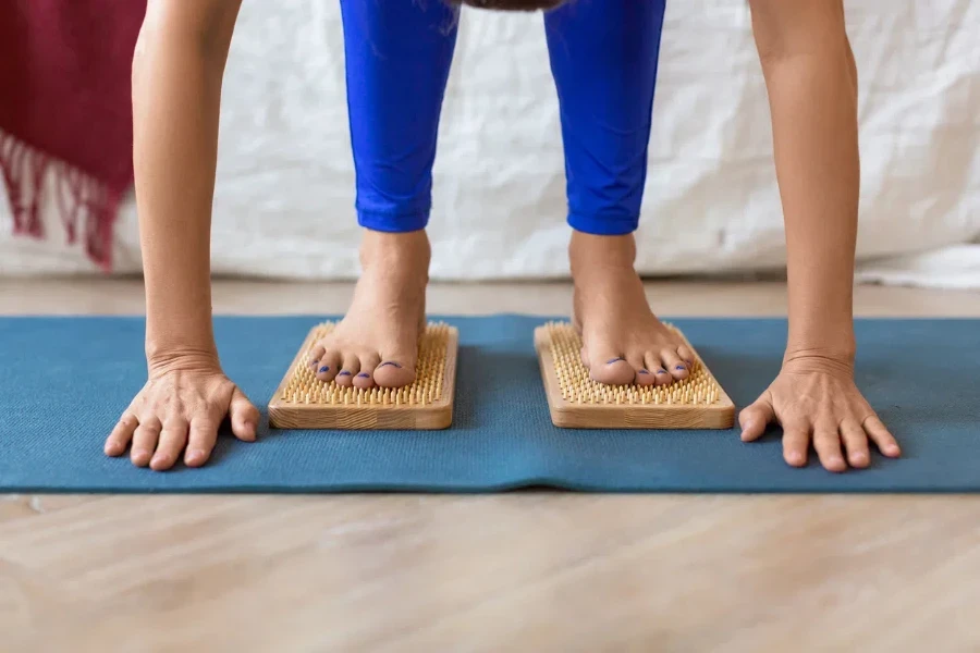 Woman standing on a board with sharp nails - feet and legs close-up